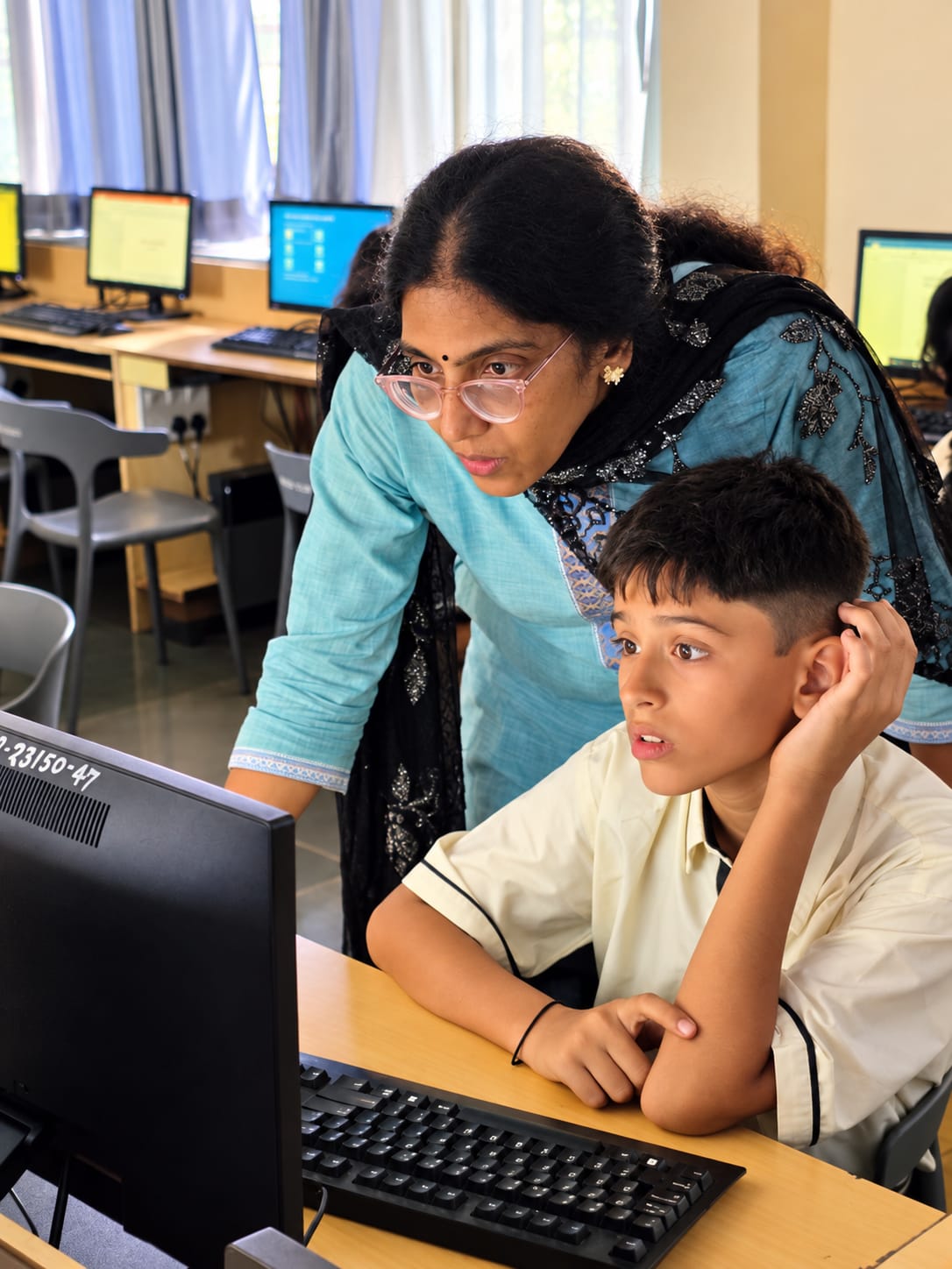 A North Point School teacher guiding a student at a computer